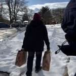 2 CORE Volunteers delivering food packages in the snow